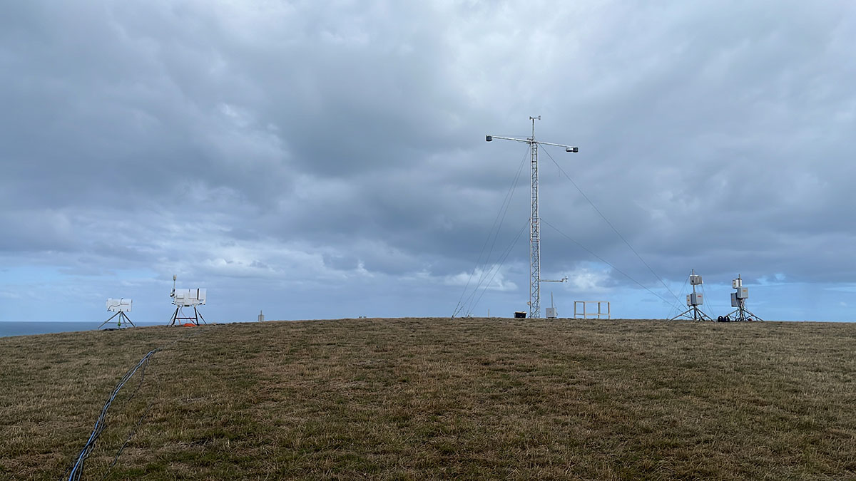 ARM instruments, including two microwave radiometers and a meteorological tower, stand on a hill overlooking the Southern Ocean.