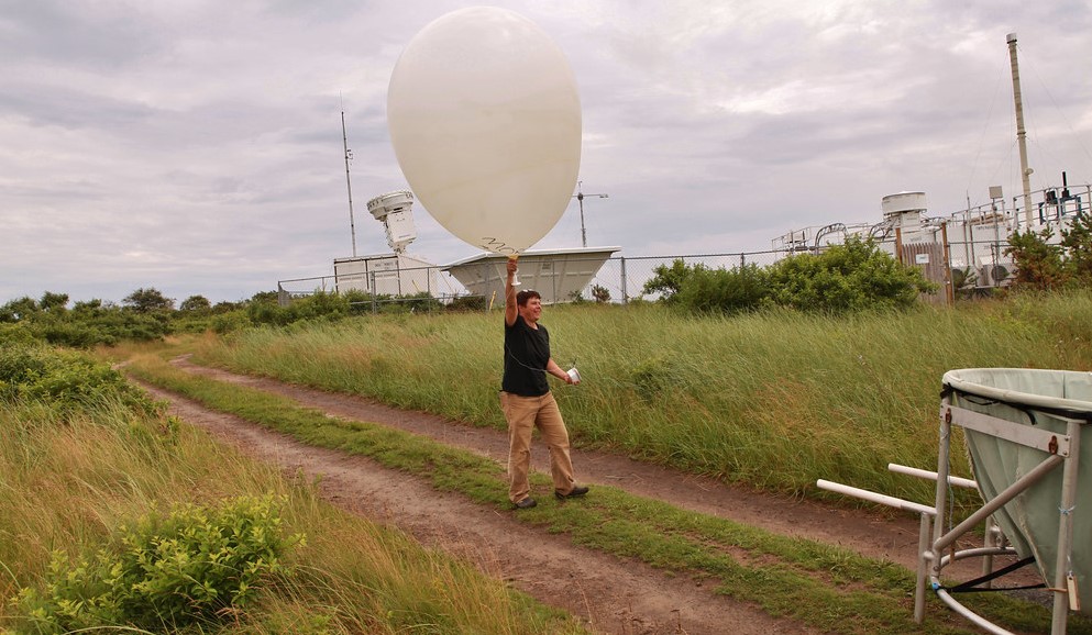 During ARM’s 2012─2013 Two-Column Aerosol Project (TCAP), radiosondes attached to weather balloons helped measure coastal wind patterns. Radiosonde launches took place four times a day from Cape Cod, Massachusetts. Here, a local “education ranger” demonstrates a hand launch for area teachers and students.