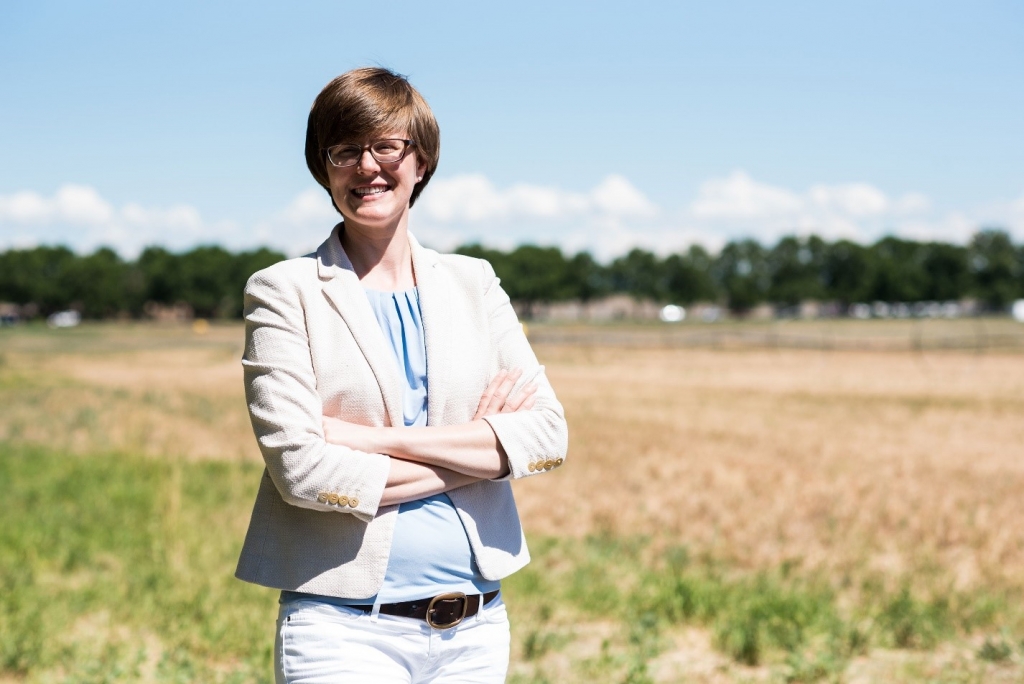 Susannah Burrows smiles for a picture in a field.