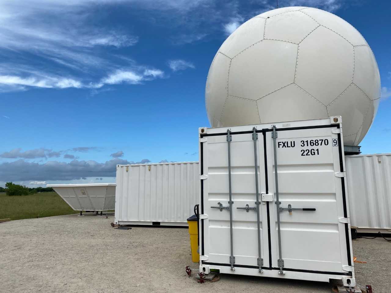 A C-Band Scanning ARM Precipitation Radar sits atop ARM containers, with a radar wind profiler visible to the left.